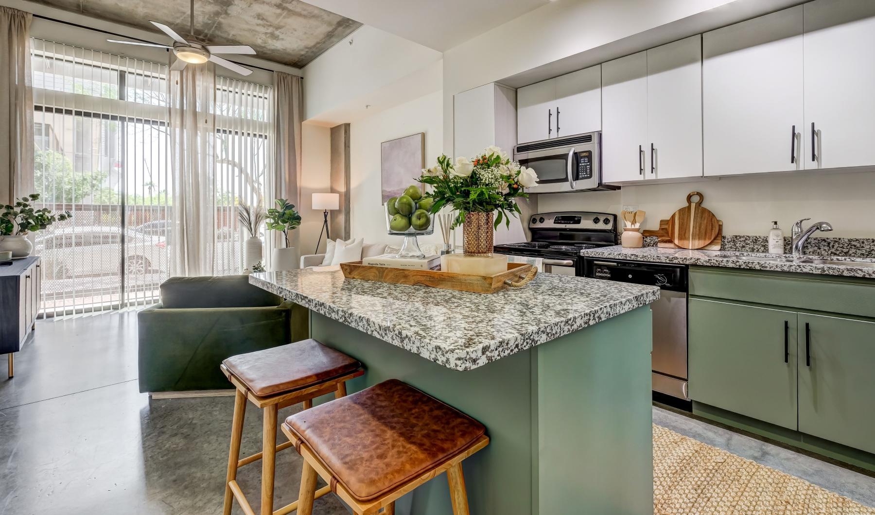 a kitchen with bar stools at island