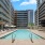 Pool and patio with beach chairs and umbrellas in the shared courtyard at Adara apartments in Downtown Phoenix, AZ. 