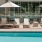 Pool and patio with beach chairs and umbrellas in the shared courtyard at Adara apartments in Downtown Phoenix, AZ. 