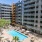 Pool and patio with beach chairs and umbrellas in the shared courtyard at Adara apartments in Downtown Phoenix, AZ. 
